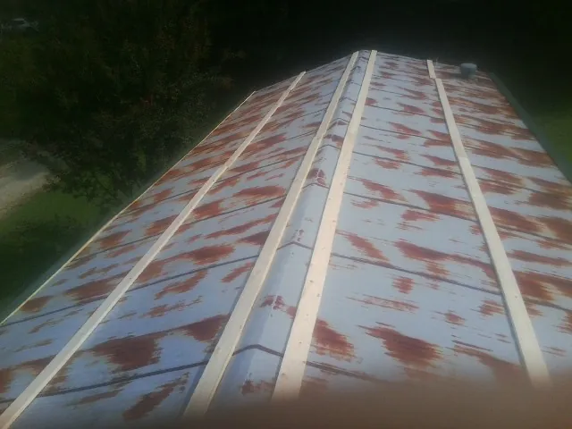 Rusted metal roof panels with new wood purlins before replacement — Storm Damage Roof Repair in Hartline by Roofing Brothers