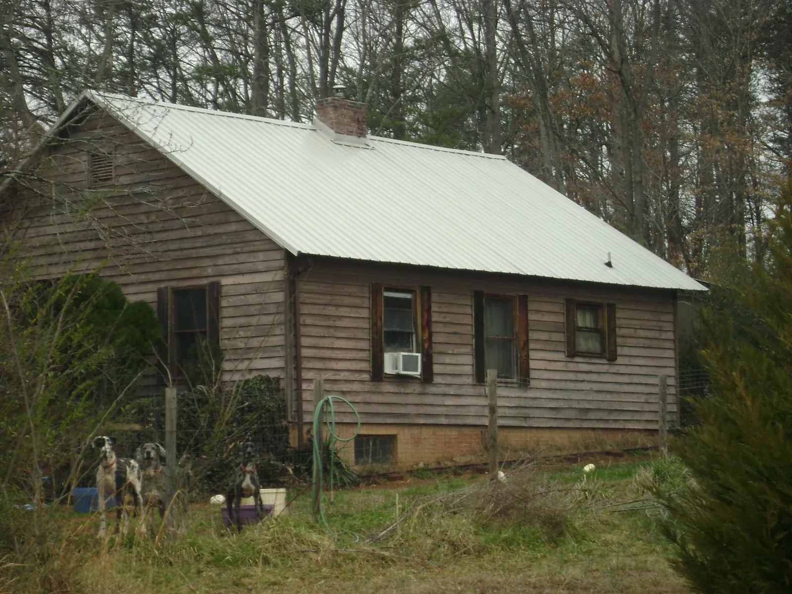 White metal roof on an old wood sided farmhouse, from a Metal Roof Installation job in Hartline